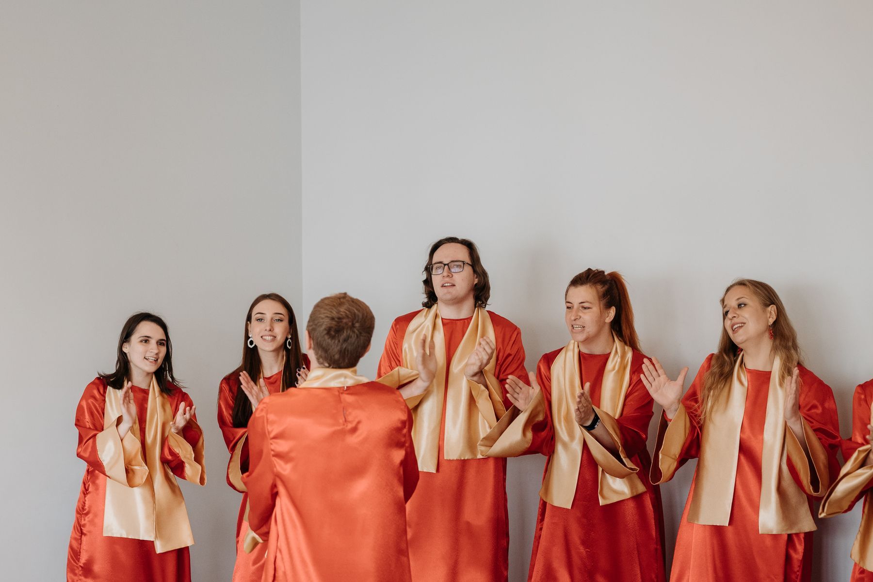 Choir members in red and gold robes singing